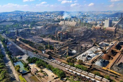 Vista aérea de uma área industrial no Rio de Janeiro, com fábricas e trechos da paisagem urbana.